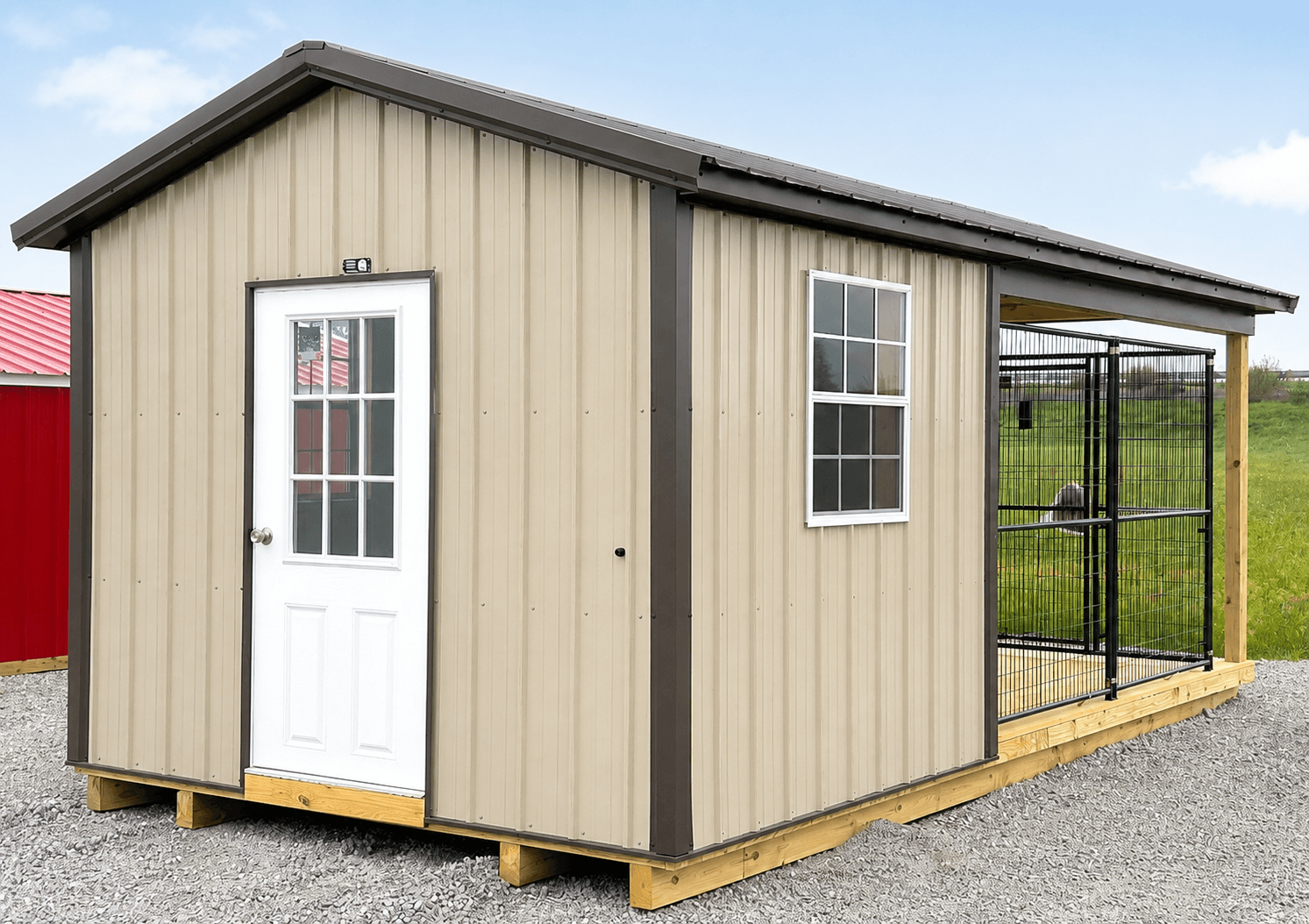 Tan dog kennel building with a white entry door, window, and attached covered run
